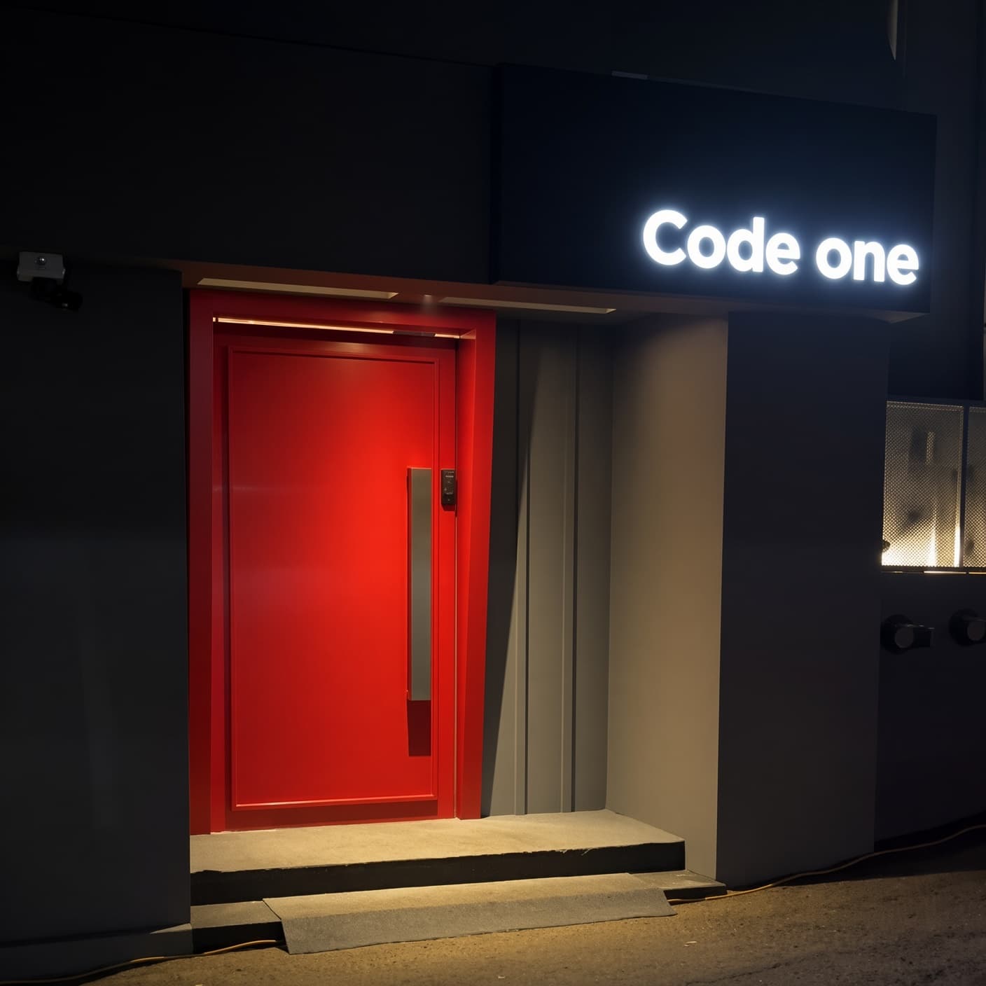 カンナム・コードワン (강남 코드원) · Code oneの看板の下に、赤い入口のドアと低い階段が見えます。