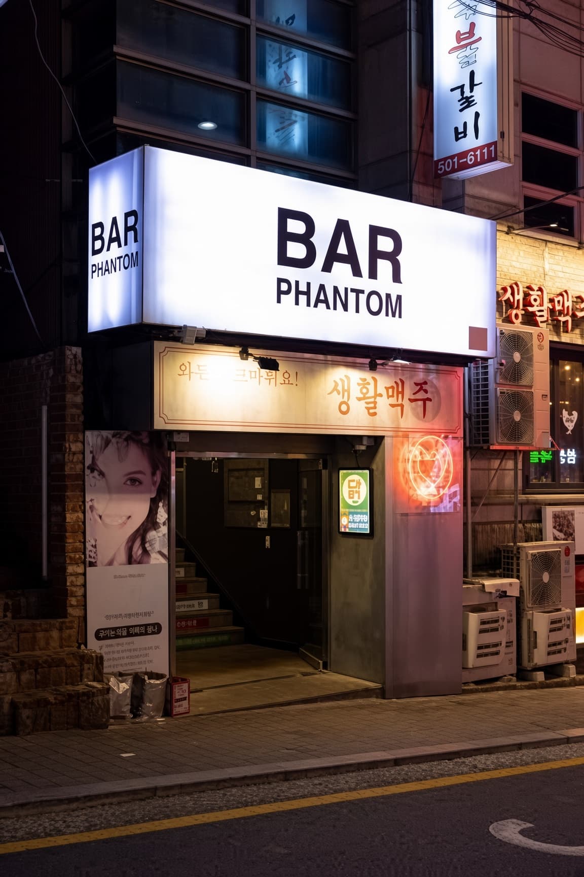 Gangnam Phantom (강남 팬텀) · A dark doorway facing the street beneath a rectangular BAR PHANTOM lightbox.