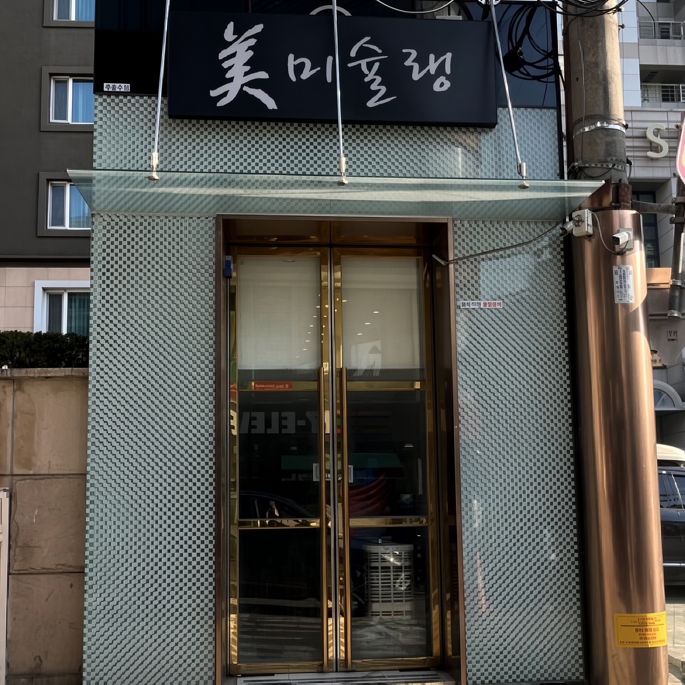 강남 엘리스 · 미슐랭 글자가 있는 간판과 금빛 테두리의 출입문이 보입니다.