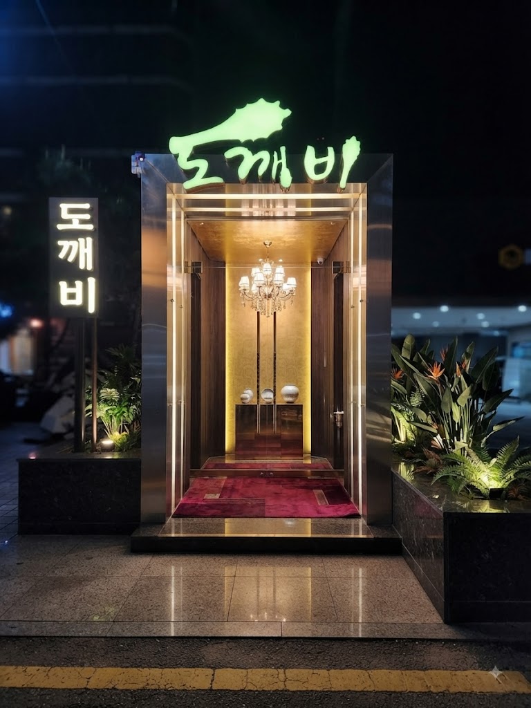 강남 도깨비 · 초록색 도깨비 간판 아래 샹들리에와 붉은 바닥의 입구가 보입니다.