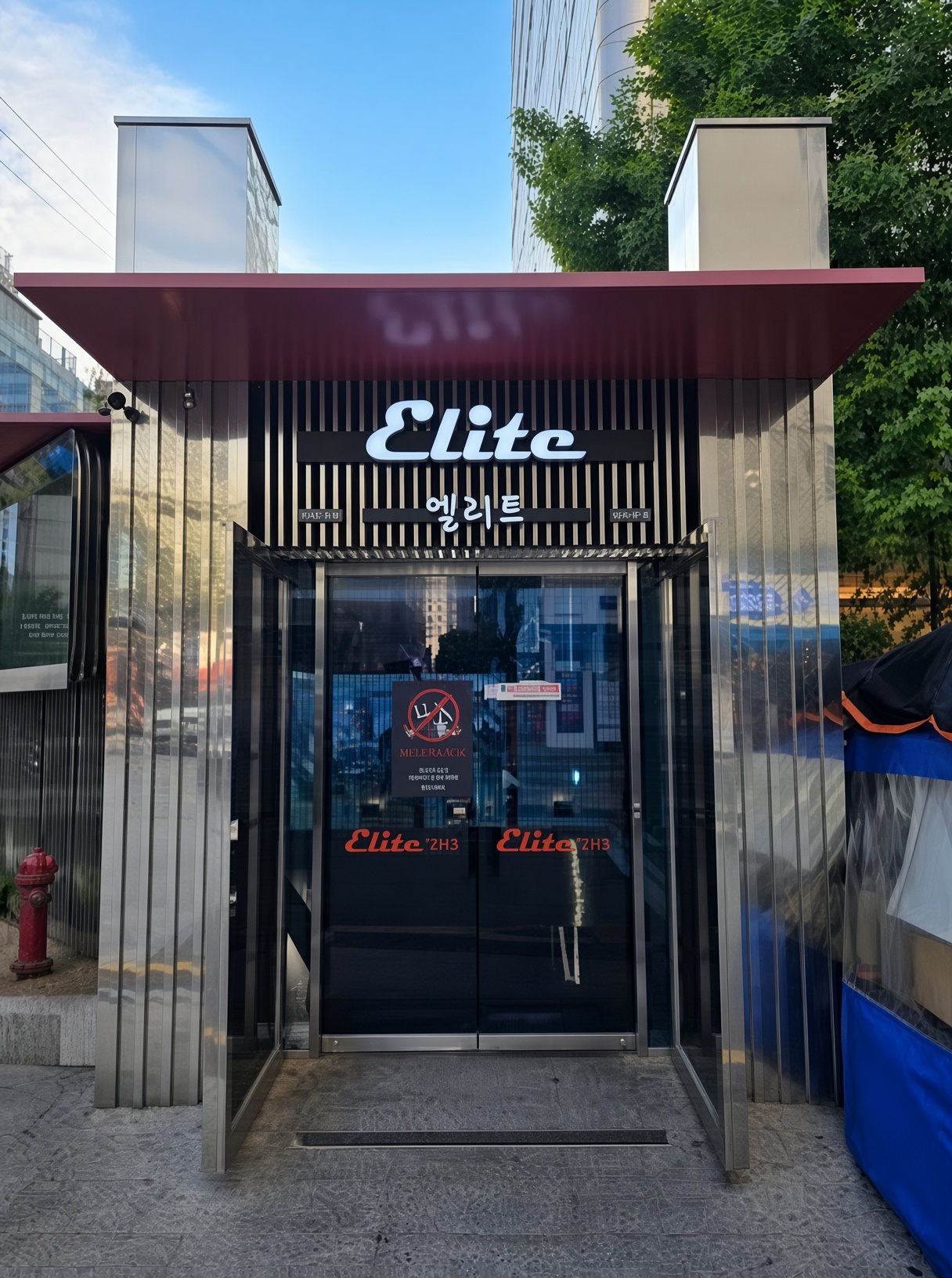 강남 엘리트 · Elite 간판 아래 세로 금속 프레임과 붉은 차양의 출입구가 보입니다.